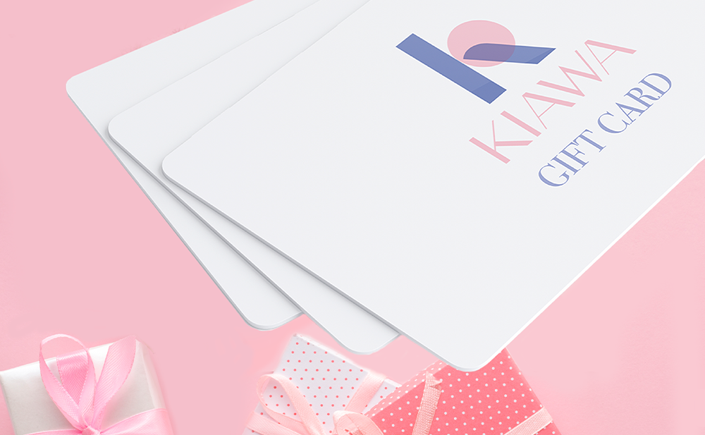 Pink background and white Kiawa gift cards over it, pink gift boxes on the bottom of the image